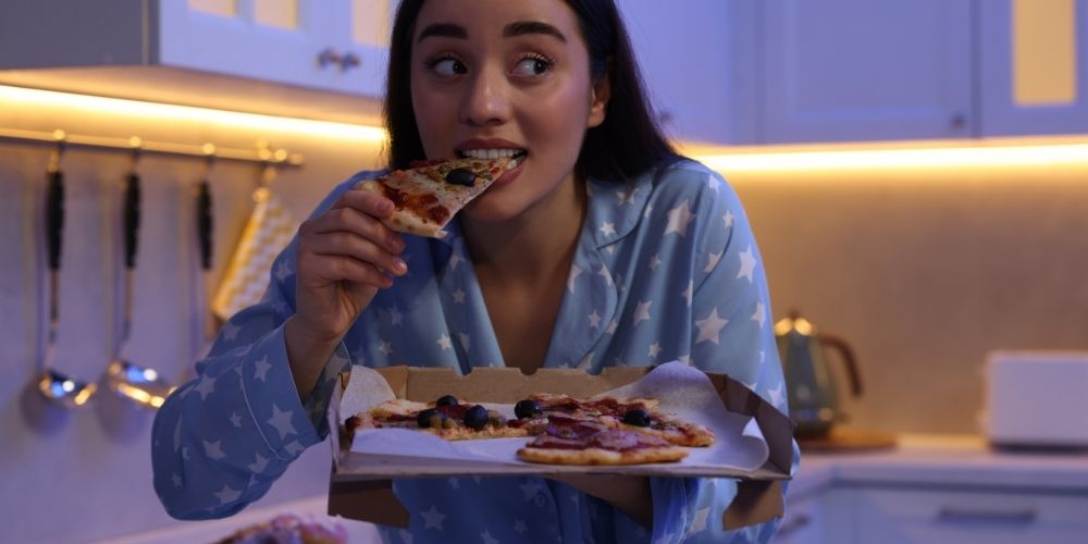 Young-Woman-Eating-Pizza-Night.jpg
