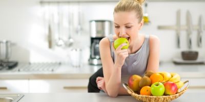 Woman eating fruits in kitchen