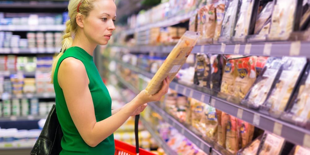 gynaika pou koitazei proion sto supermarket